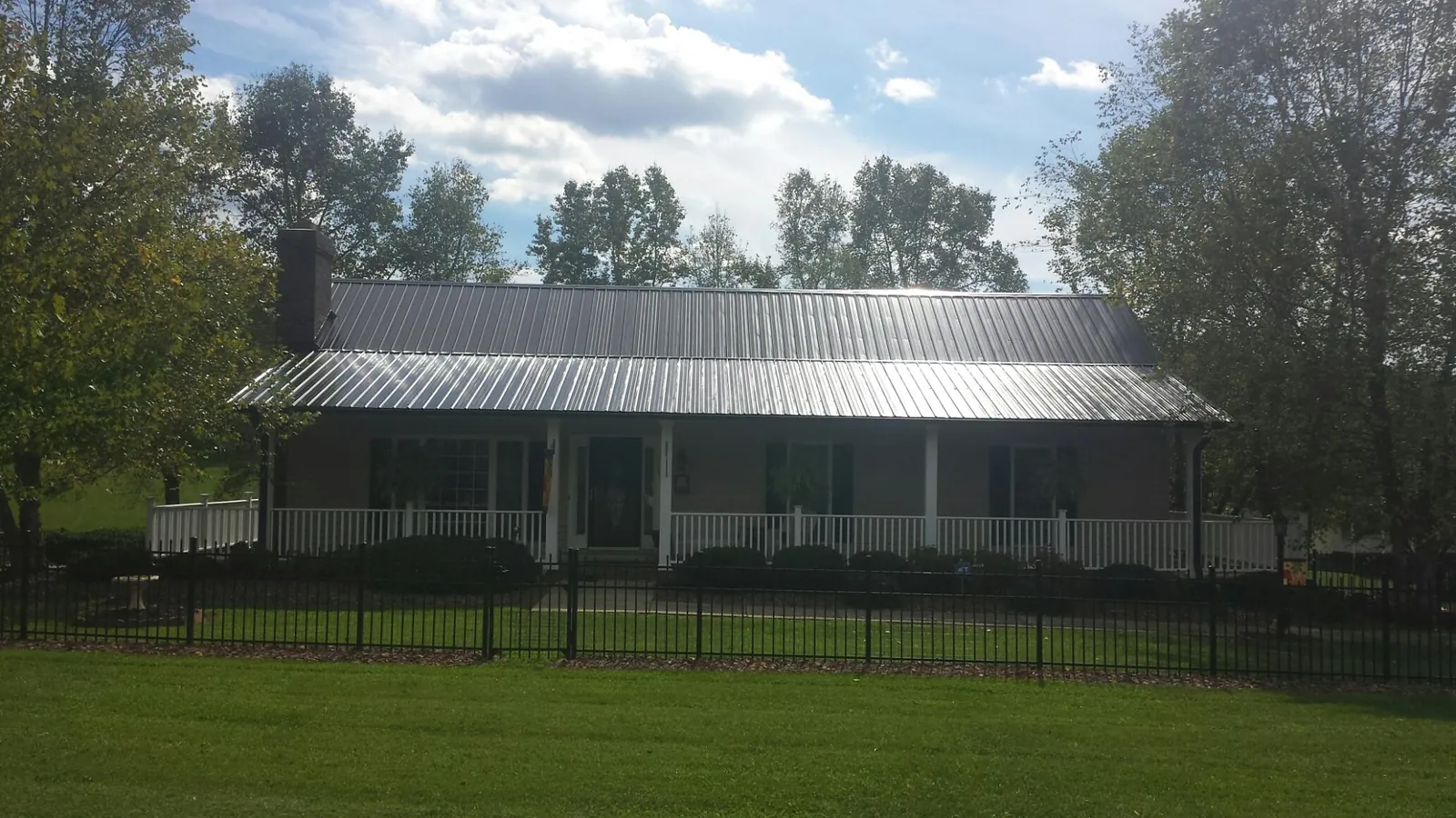 Gray metal roof on a brick ranch with a full width front porch — Gutter Guard Installation work by our crew in Hawthorne